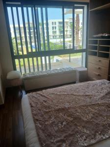 a bedroom with a bed and a large window at Prestigia plage des Nations in Sale +5 photos