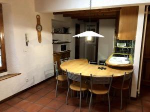 a kitchen and dining room with a wooden table and chairs at Appartement Les Angles villages in Les Angles +5 photos