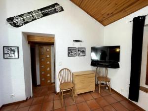 a living room with two chairs and a flat screen tv at Appartement Les Angles villages in Les Angles