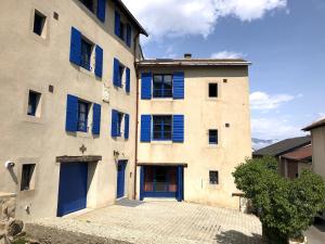 a large building with blue shutters on it at Appartement Les Angles villages in Les Angles