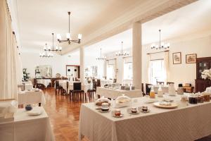a dining room with white tables and chairs at Casa do Lugar de Paços in Caldelas