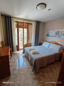 a bedroom with a bed and a large window at Casa Placet de Sant Joan Apto in Morella