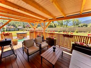 a deck with chairs and a wooden pergola at Domček pod Vežami s vírivkou a grilom, pri termálnom kúpalisku in Liptovský Ján