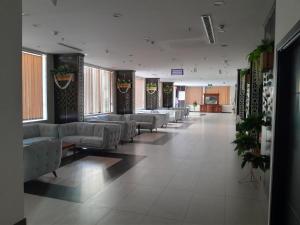 une salle d'attente avec des canapés blancs et des plantes dans l'établissement فندق مناسك الرشاد الفندقية, à La Mecque