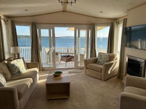 a living room with a view of the ocean at Knightsbridge 2 Bedroom Lodge in Lytchett Minster