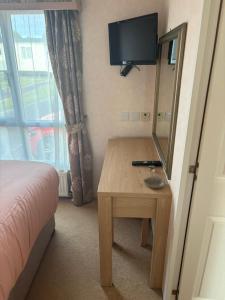 a bedroom with a bed and a table with a mirror at Knightsbridge 2 Bedroom Lodge in Lytchett Minster