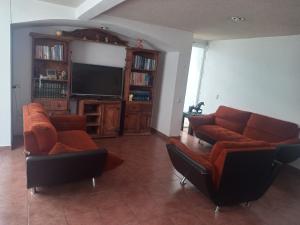 オアハカにあるCasa familiar cerca del Centroのソファと薄型テレビのあるリビングルーム
