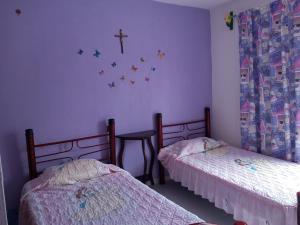 オアハカにあるCasa familiar cerca del Centroのベッド2台が備わる客室で、壁にクロスが付いています。