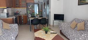 a living room with a couch and a table at DESPOINA APARTMENT with garden in Nea Michaniona