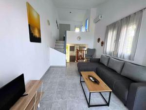 a living room with a couch and a table at Elegant Maisonettes Elena in Nea Potidaea