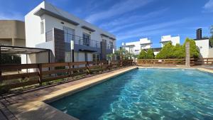 a swimming pool in front of a house at ByF apart duplex excepcional en complejo Amaiur DPTO N5 Av Alem Norte in Federación