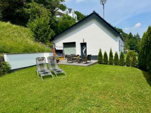 two chairs sitting on a lawn in front of a house at Wellness Ferienhaus in Mechernich