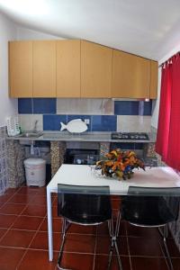 a kitchen with a white table and two black chairs at Casa do Monte in Castro Daire