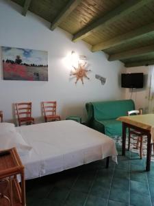 a bedroom with a bed and a table and chairs at A Cà du Paise in Carloforte