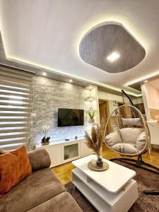 a living room with a couch and a tv at Centar Lux 3M in Zlatibor +4 photos