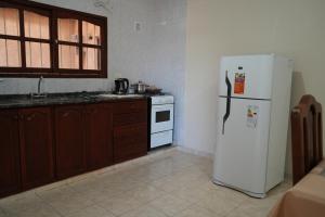 a kitchen with a white refrigerator and a stove at Olimpo Apart in Santiago del Estero