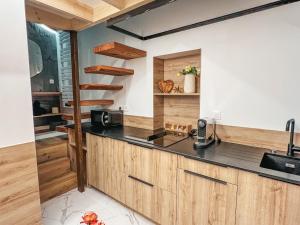 a kitchen with wooden cabinets and a counter top at Galatea Suite Luxury and Jacuzzi in Perros-Guirec
