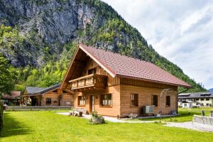 a log cabin with a mountain in the background at W & S Executive Apartments - Hallstatt II in Hallstatt