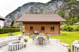 ein Haus mit einem Tisch und Stühlen davor in der Unterkunft W & S Executive Apartments - Hallstatt II in Hallstatt