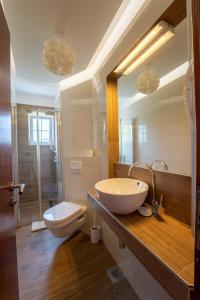 een badkamer met een wastafel, een toilet en een spiegel bij Beach Apartments Villa Holiday in Živogošće