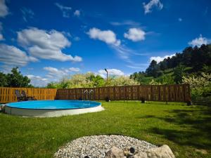 a backyard with a swimming pool and a wooden fence at Várhegy apartman in Neszmély