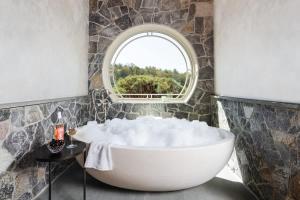 a bathroom with a large tub and a window at Private 37 Acre Lake Estate On 164 Acres - 11 Br in Highland