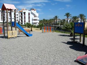 a playground with a slide in front of a building at Apartamento VenAVera Playa Altos de Nuevo Vera I4-0A Bajo Primera Linea WIFI in Vera