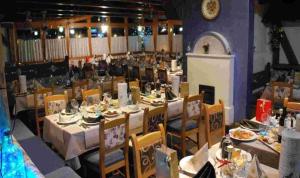 a dining room with tables and chairs with food on them at Casa Ciclamino Val Di Sole 10 pax 7 nights in Cassana