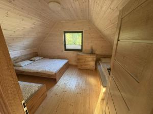 a room with two beds in a wooden cabin at Szare Domki in Mrzeżyno