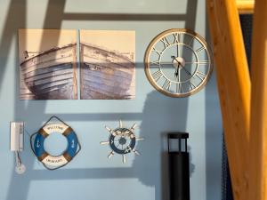 a clock and other items on a wall at Mazurski Apartament in Dadaj