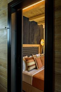 Un dormitorio con una cama con almohadas encima. en Olive Mykonos Villas, en Ano Mera