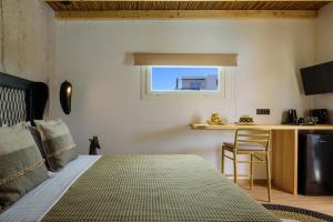 a bedroom with a bed and a table and a kitchen at Olive Mykonos Villas in Ano Mera
