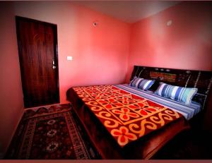 a bedroom with a large bed with red walls at Pandavas Homestay in Rudraprayāg +18 photos