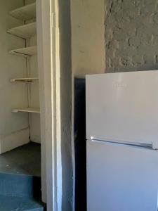a white refrigerator in a room with a shelf at Little Rock Mountain Cottage in Somerset East +4 photos