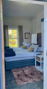 a bedroom with a large bed and a window at Little Rock Mountain Cottage in Somerset East