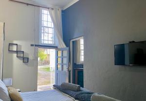 a bedroom with a bed and a television on a wall at Little Rock Mountain Cottage in Somerset East