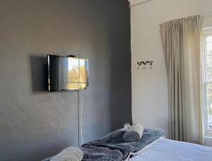 a bedroom with a bed with a tv on the wall at Little Rock Mountain Cottage in Somerset East