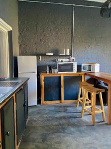 a kitchen with a counter with a refrigerator and a table at Little Rock Mountain Cottage in Somerset East