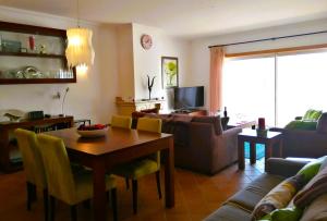 a living room with a table and a couch at The Sea Breeze Haven in Praia d'el Rey in Casal da Lagoa Seca