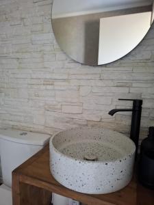 a bathroom with a stone sink and a mirror at EmvaSea Seaside apartment in Monemvasia +31 photos