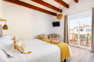 a white bedroom with a bed and a large window at Villa Menurka I in Cala en Blanes +22 photos