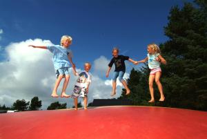 a group of children jumping on a trampoline at Vejers Family Camping & Cottages in Vejers Strand