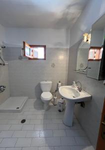 a bathroom with a toilet and a sink and a tub at Martha's home in Nea Vrasna +22 photos