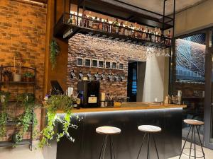 a bar with two stools and a brick wall at MK Apart Boutique 2 in Voluntari