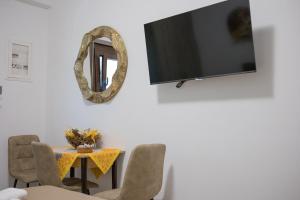 a dining room with a table and a mirror at Gatzea Eden Garden - DELUXE Δίκλινο δωμάτιο in Kato Gatzea