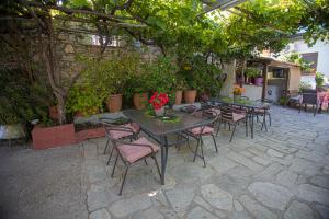 a patio with tables and chairs under a pergola at Gatzea Eden Garden - DELUXE Δίκλινο δωμάτιο in Kato Gatzea