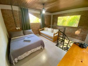 a bedroom with a bed and a chair and a window at Casa Pasárgada in Palmas