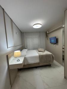 a bedroom with a bed and a table with a lamp at Apartamento alto padrao in Nova Prata