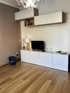 a kitchen with white cabinets and a flat screen tv at Bibi Pied-à-Terre Vetra - Two Rooms Apartment in Milan