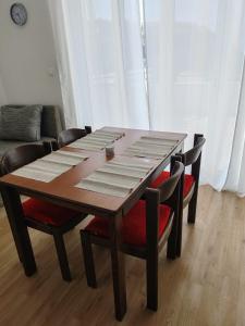 a wooden table with four chairs around it at Apartman Marki in Krvavica